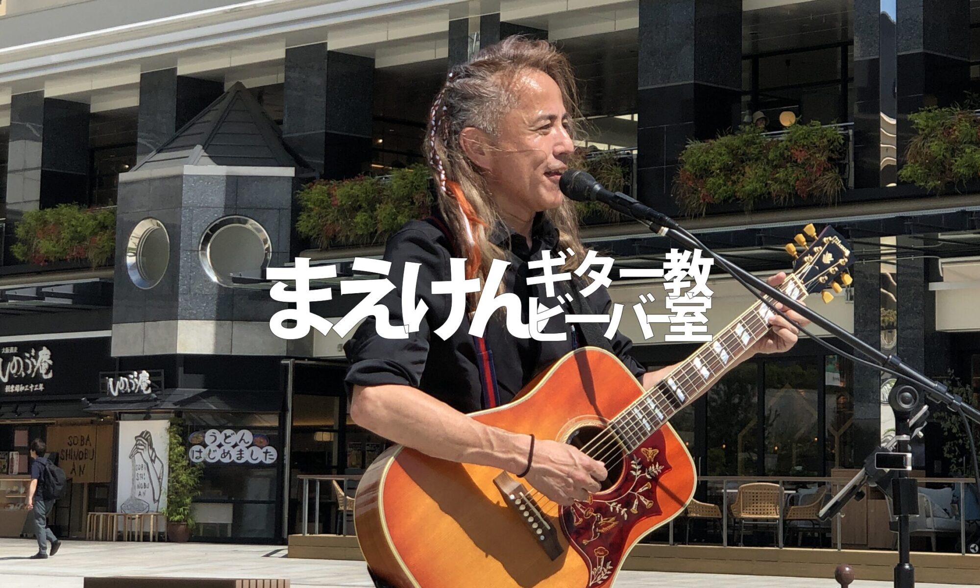 神戸のギター教室 まえけんビーバーギター教室|講師が屋外でギター演奏している様子
